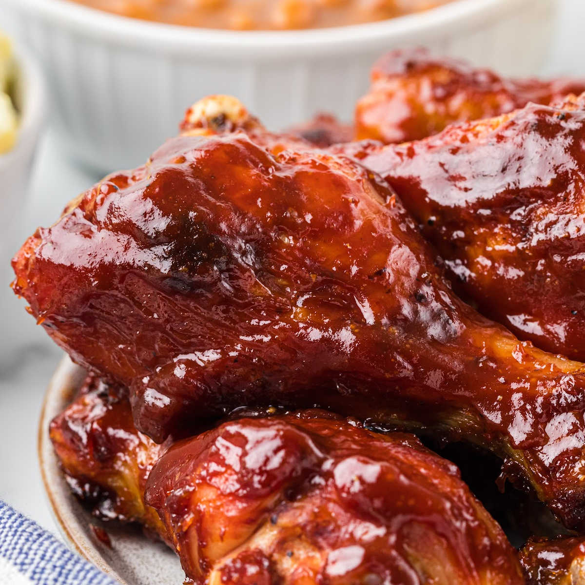 close up of chicken drumstick covered in barbecue sauce.