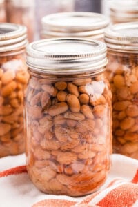 Close-up of a mason jar filled with pressure canned pinto beans with additional jars in the background.