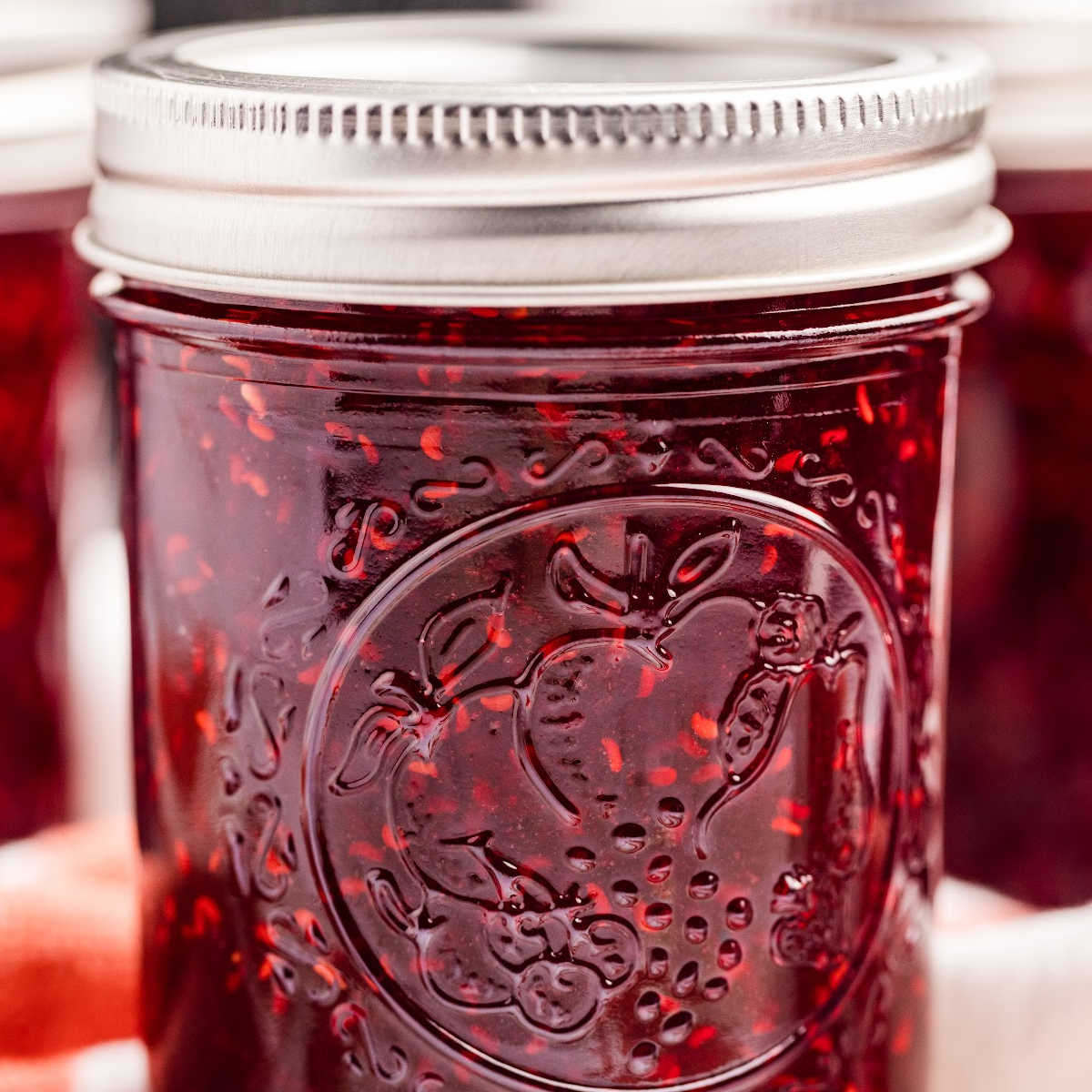 Close-up of a single jar of homemade raspberry jam.