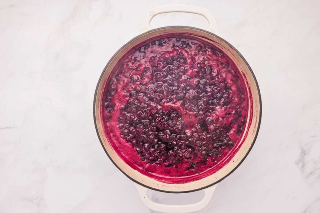 a large pot filled with simmering blueberry mixture.