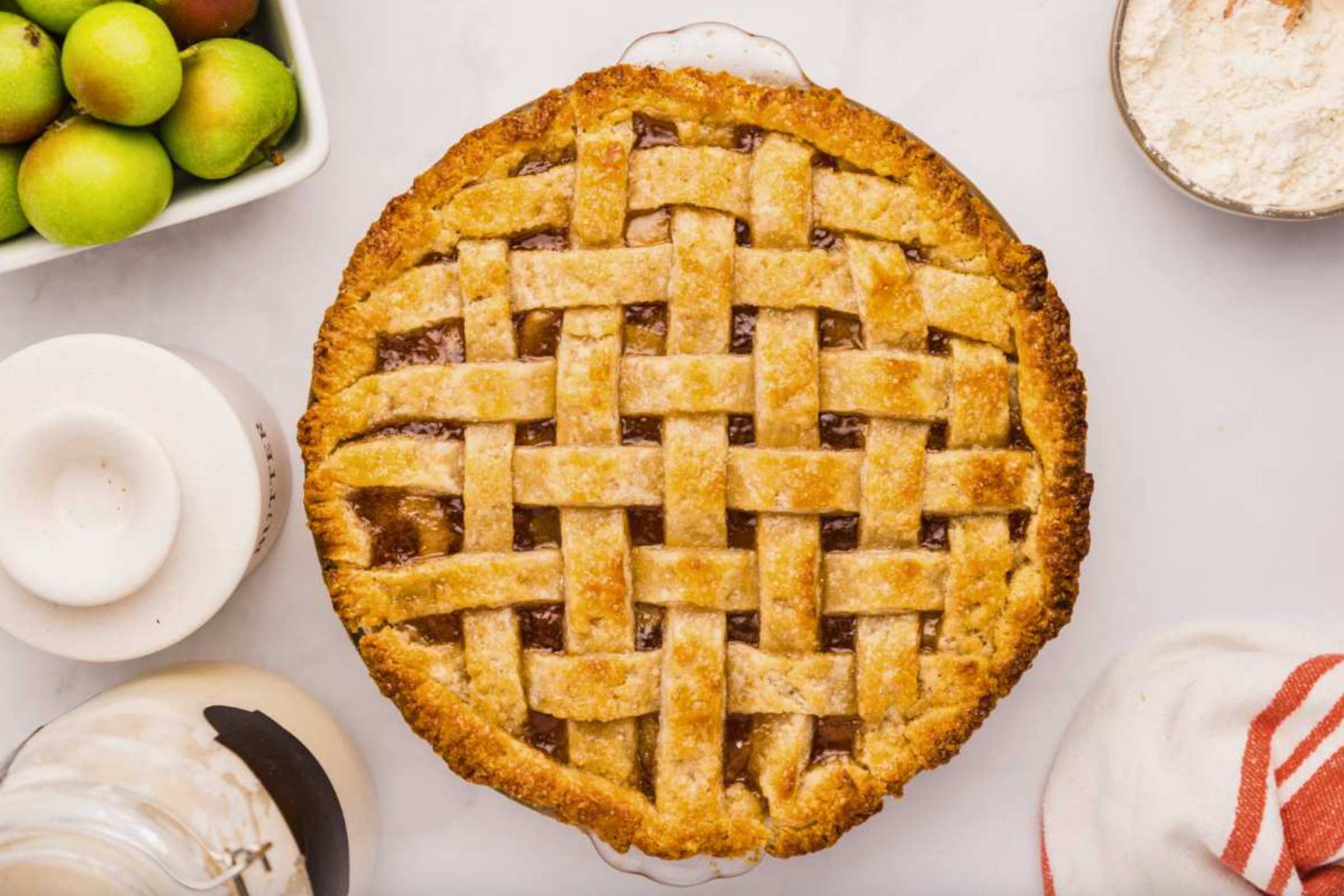 A beautifully woven lattice pie crust, baked to a golden brown, resting on a kitchen counter.