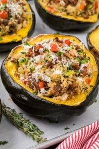 Final dish of sausage stuffed acorn squash, garnished with parsley and ready to serve.