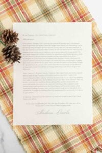 overhead view of printed thanksgiving proclamation on plaid tablecloth.