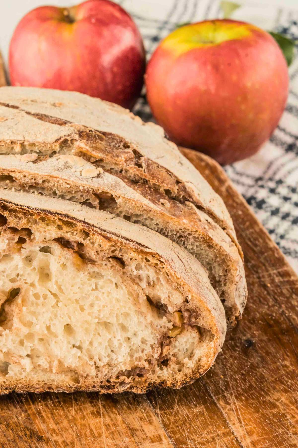 front shot of inside of bread sliced up with apples in background.