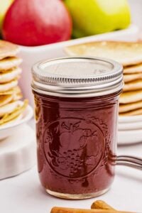 front shot of jar of apple syrup on counter.