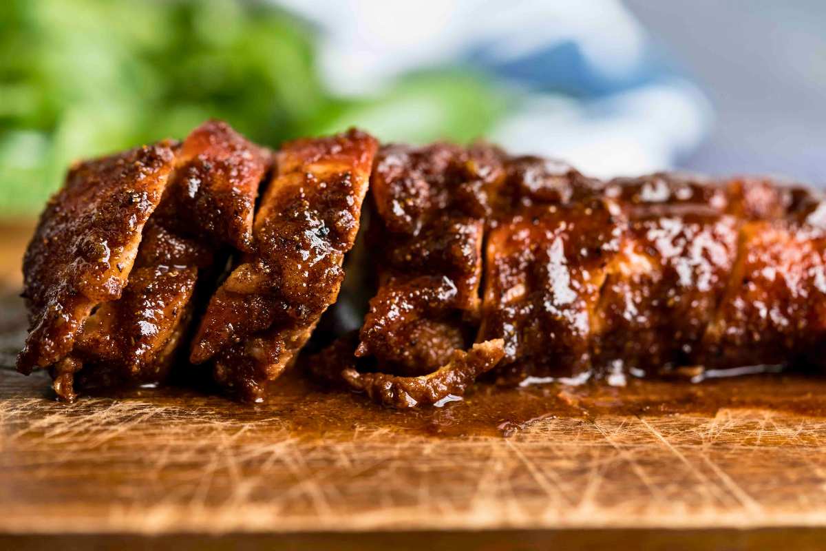 side view of cooked and glazed pork tenderloin sliced up.