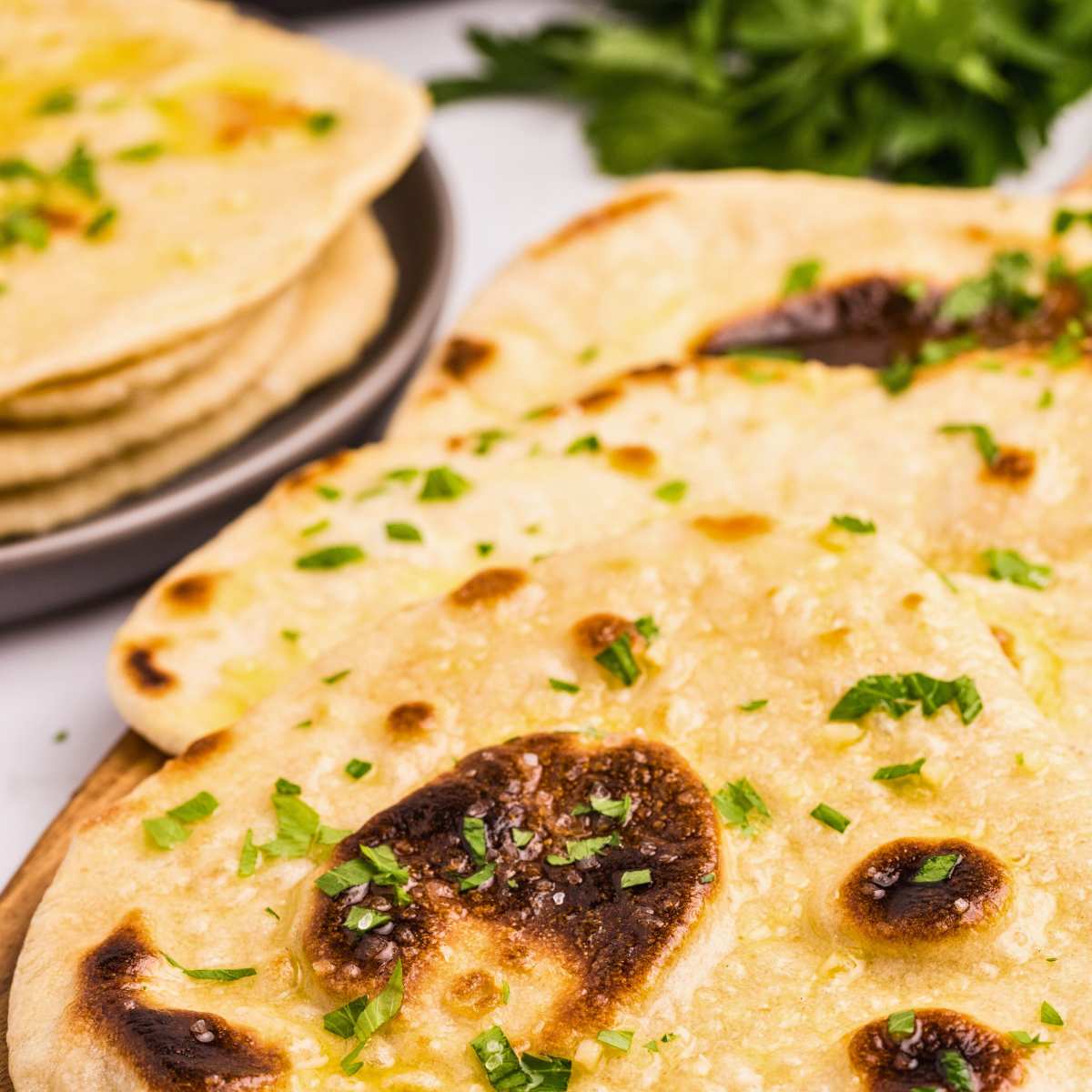 close up shot of naan sprinkled with parsley.