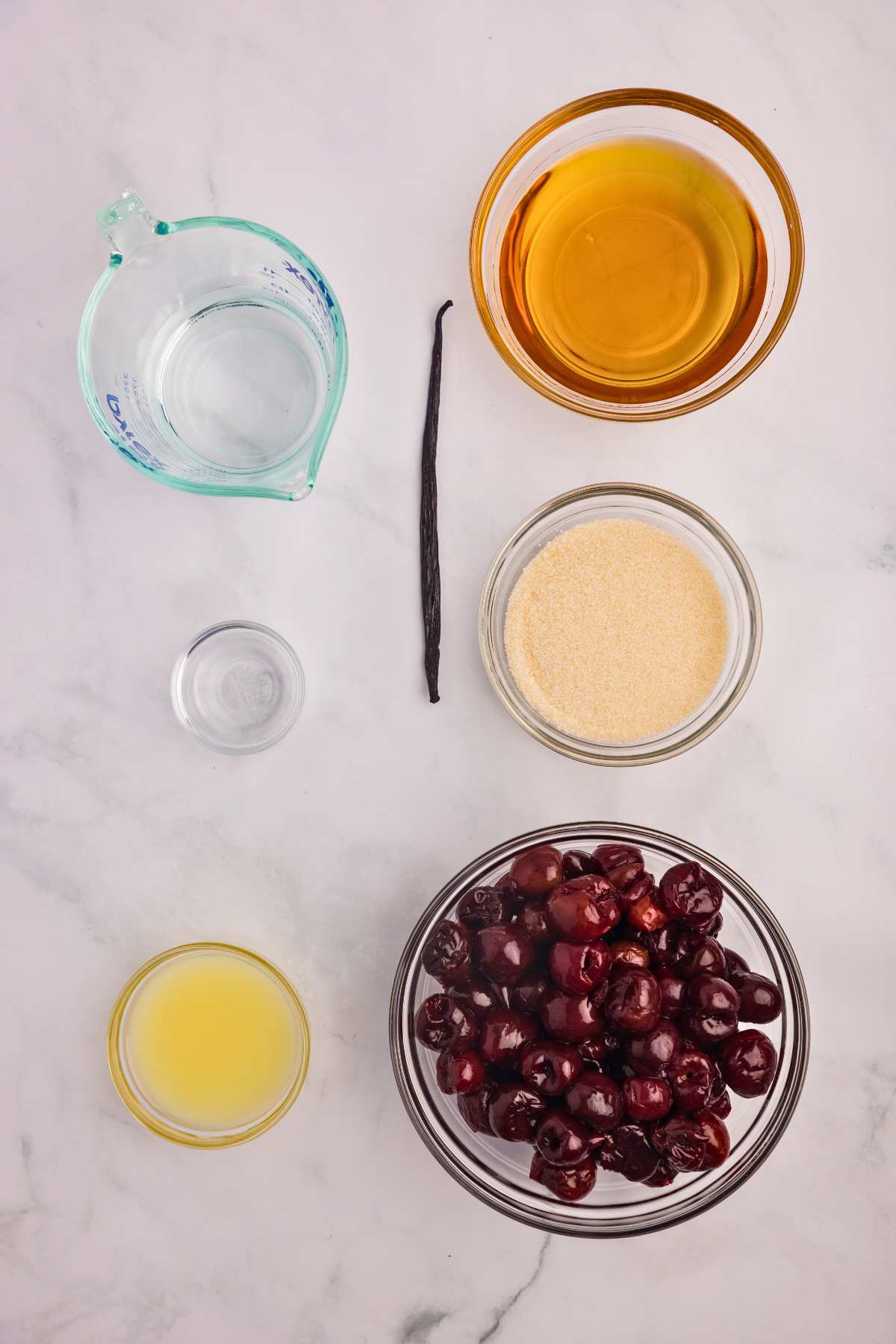 ingredients for bourbon cherries measured out in bowls on counter.