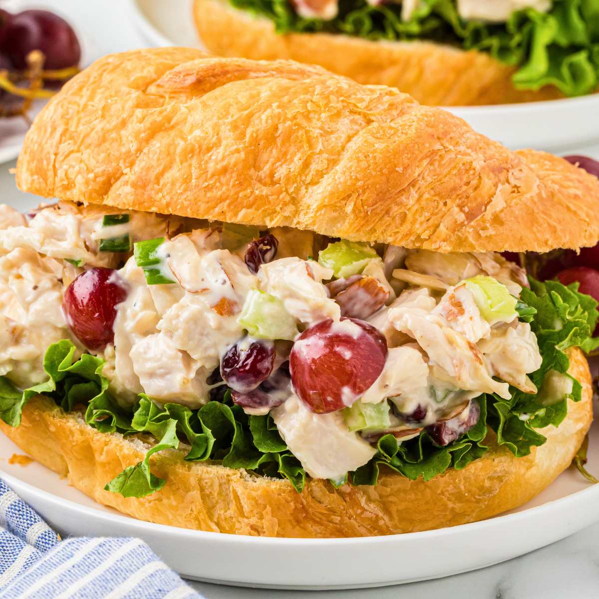 front shot of filled croissant sandwich on plate.