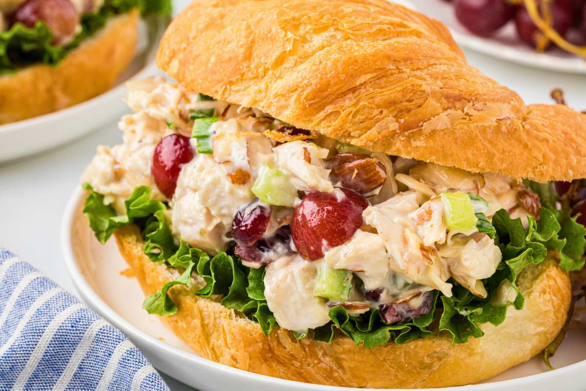 close up side shot of filled croissant sandwich on plate.