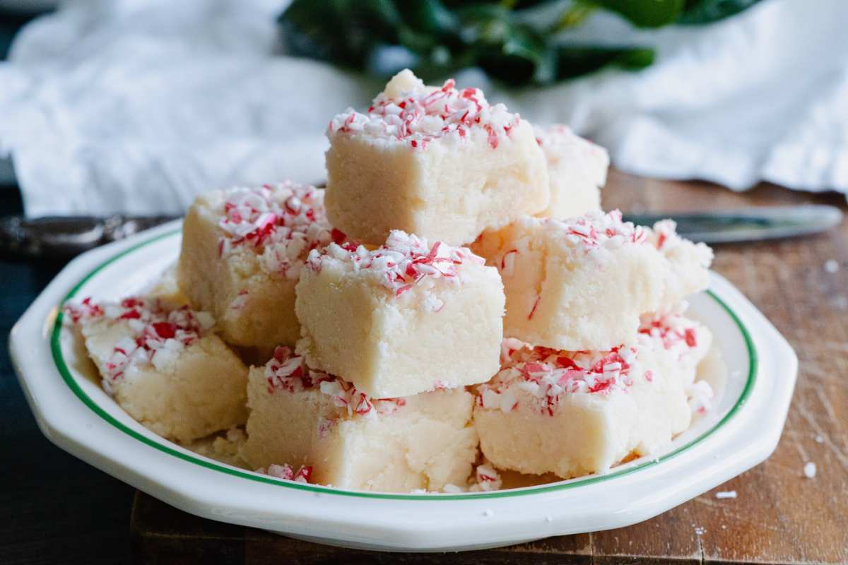 peppermint fudge pieces stacked on top of a plate.