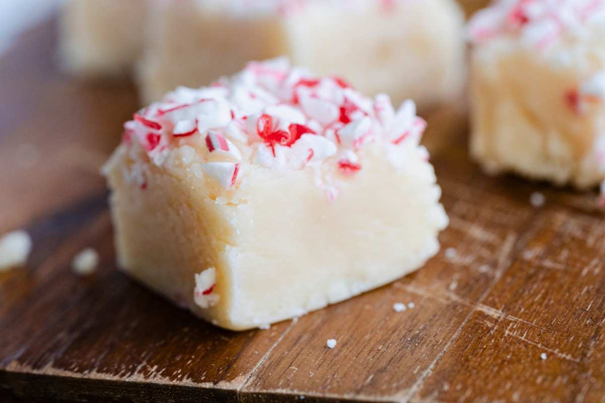 close up of one peppermint fudge piece on wooden board.