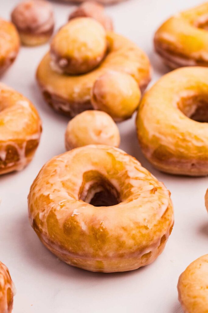 front shot of doughnuts and doughnut holes arranged on counter.