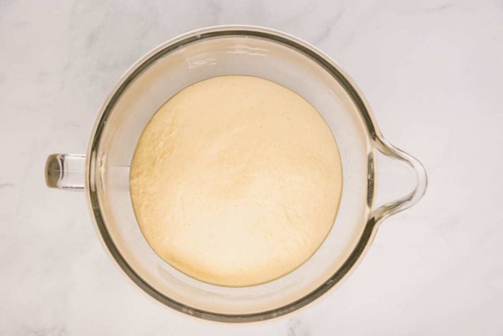 risen dough in glass bowl.
