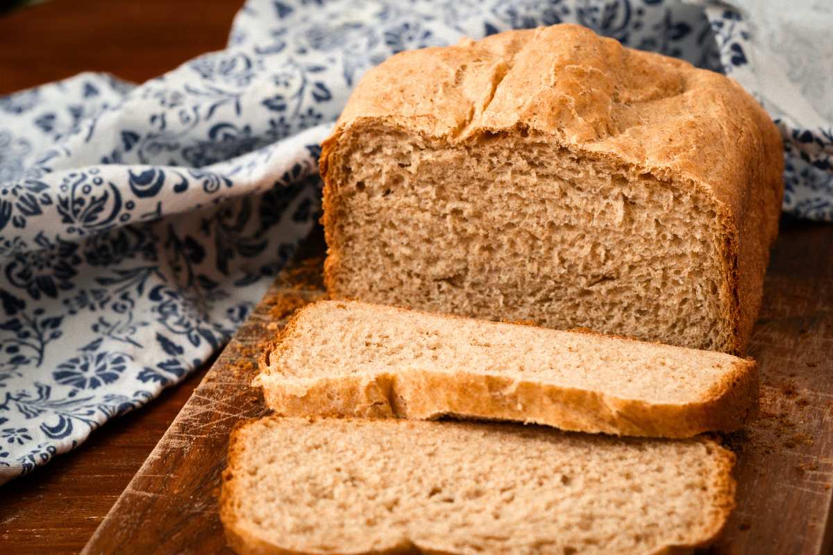 honey wheat bread loaf with two slices cut.