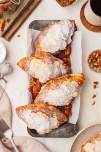 overhead shot of 4 sugar dusted pecan pie croissants on tray on counter.