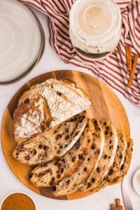 top view of boule bread with half of it sliced up on wooden board.