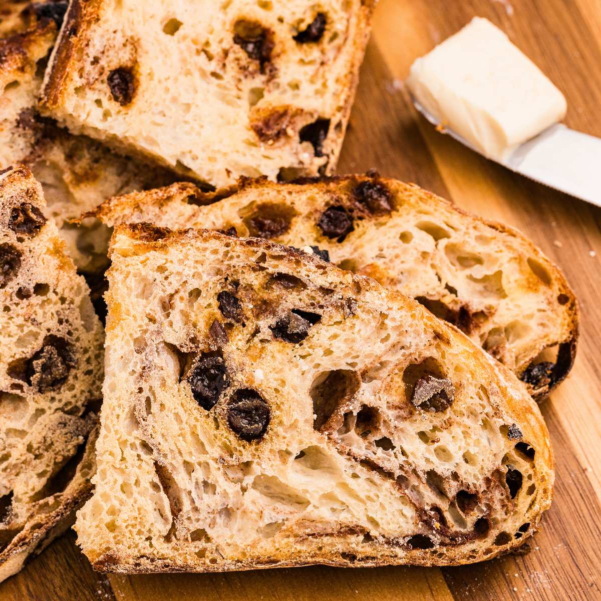slices of cinnamon raisin bread on wooden board.