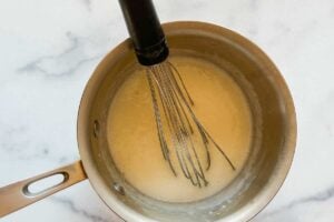 ingredients in saucepan with whisk.