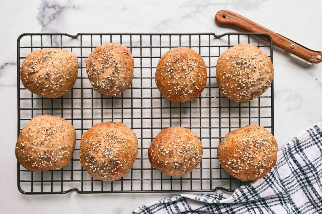 baked seeded rolls cooling on wire rack.