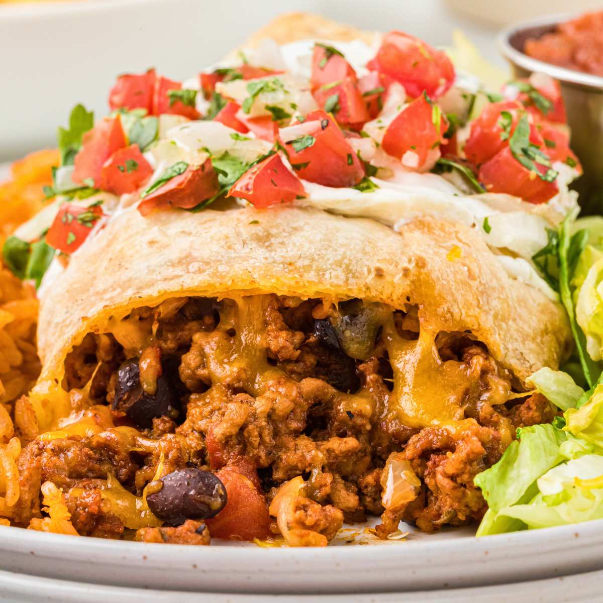 baked beef chimichanga on plate showing filling.