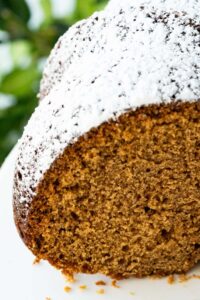 sugar dusted gingerbread bundt cake cut to reveal insde.