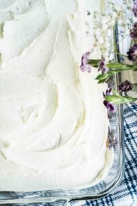 overhead view of white sheet cake with purple flowers.