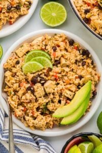 bowl of cilantro chicken rice topped with lime and avocado.