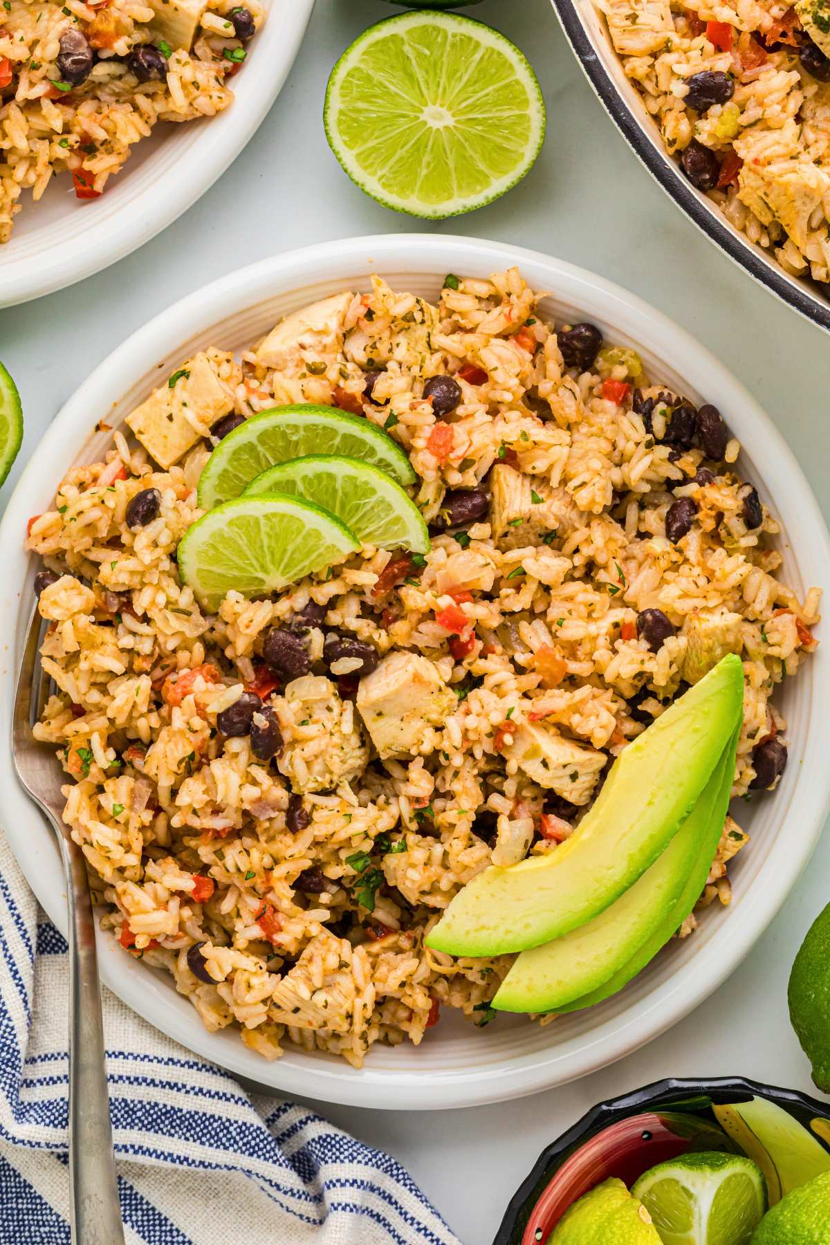 bowl of cilantro chicken rice topped with lime and avocado.