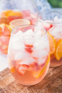 Two glasses of sangria with pitcher and background