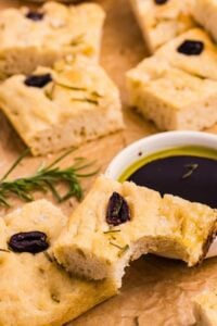 pieces of focaccia bread with a bowl of oil to dip.