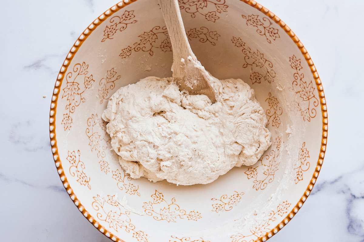dough in bowl with wooden spoon.