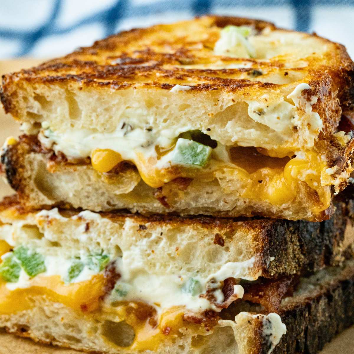 cut open grilled cheese halves stacked showing cheesy inside.