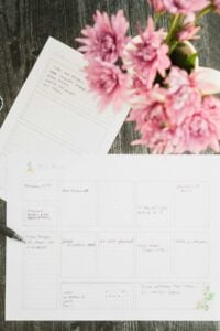 lemon planner pages on table next to vase of pink flowers.