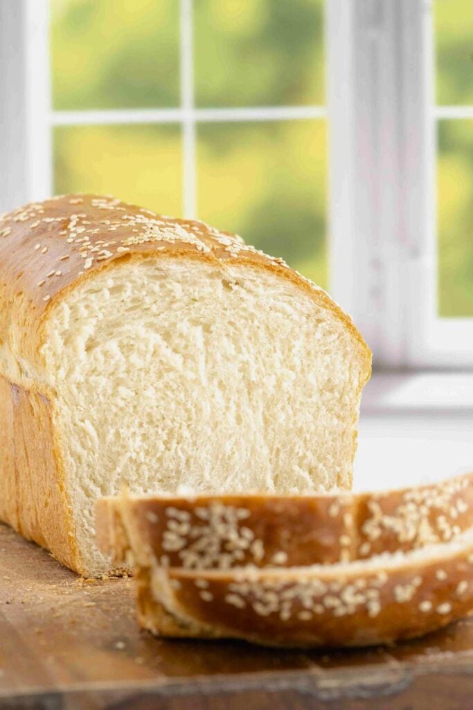 white sandwich loaf sliced on board in front of window.