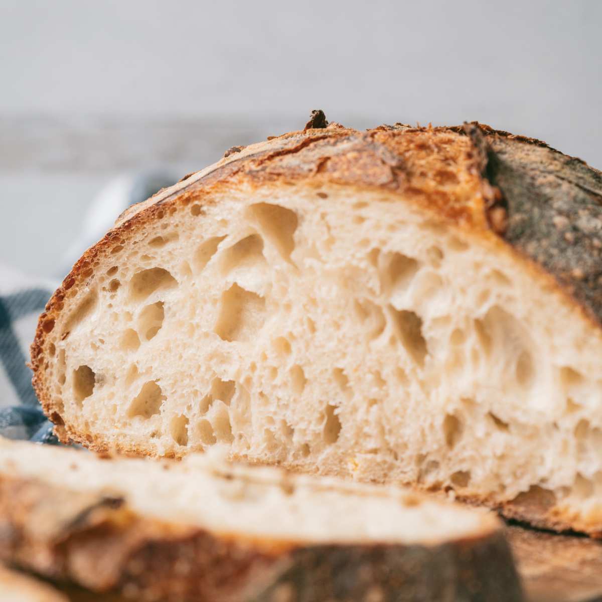 sliced loaf of crusty sourdough round bread.