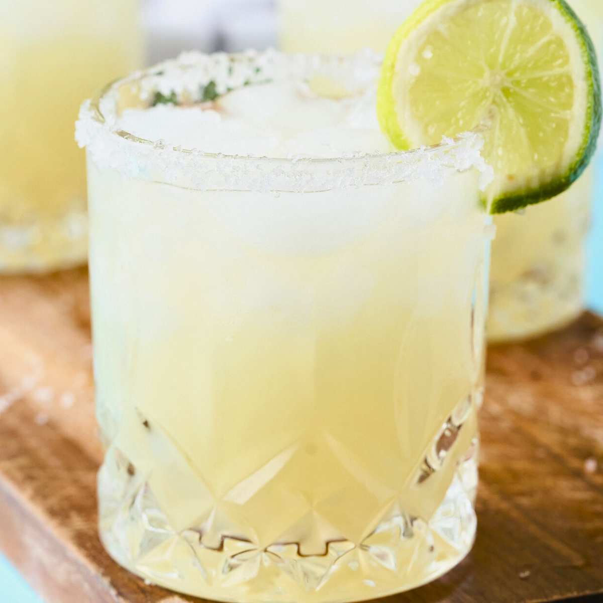 salt-rimmed glass of key lime margarita with lime slice on rim.
