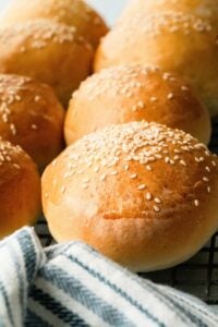 burger buns lined up with blue striped towel.