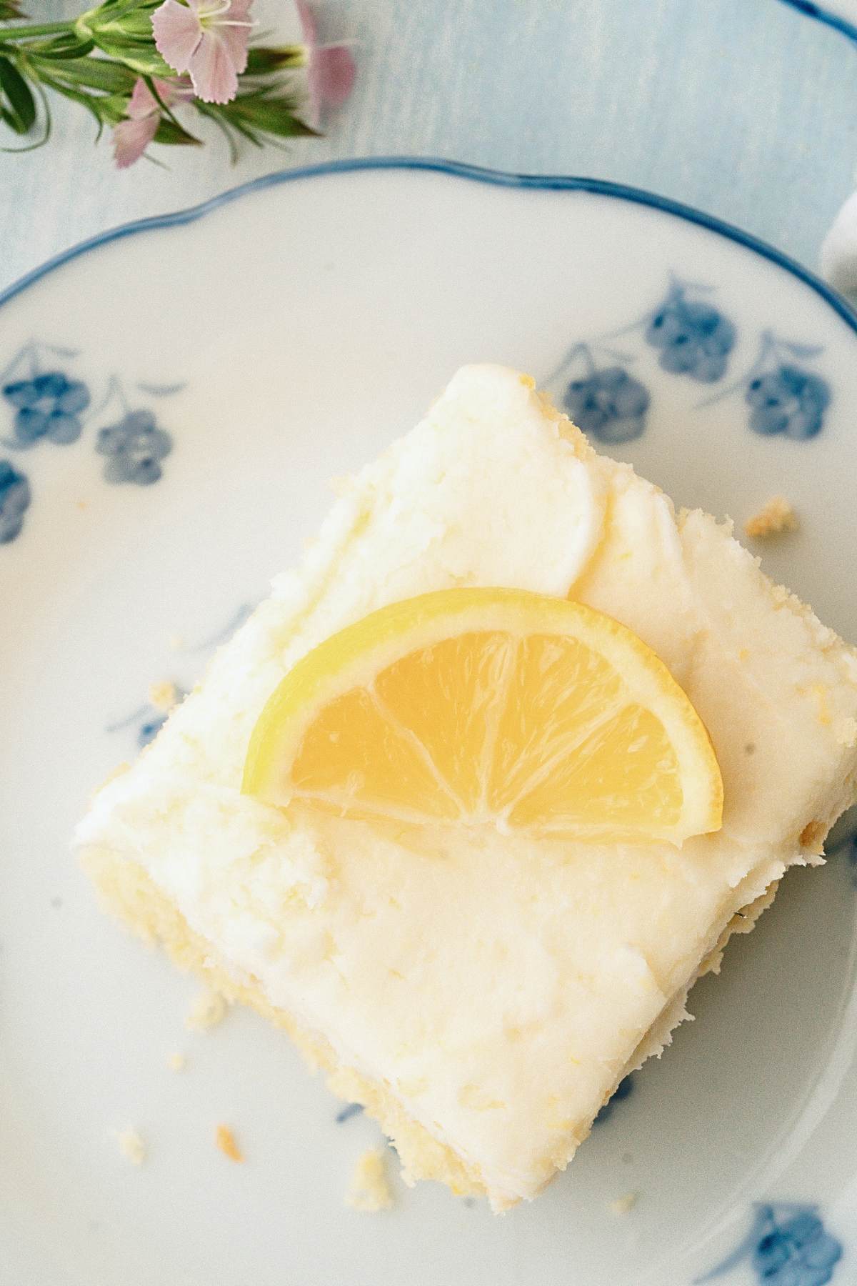 overheard view of square cake with slice of lemon
