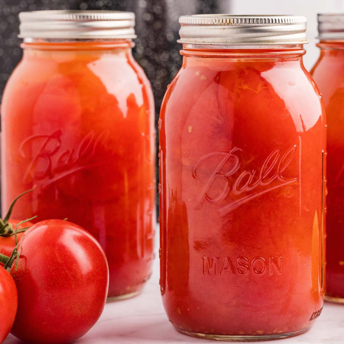 quart jars filled with whole tomatoes.