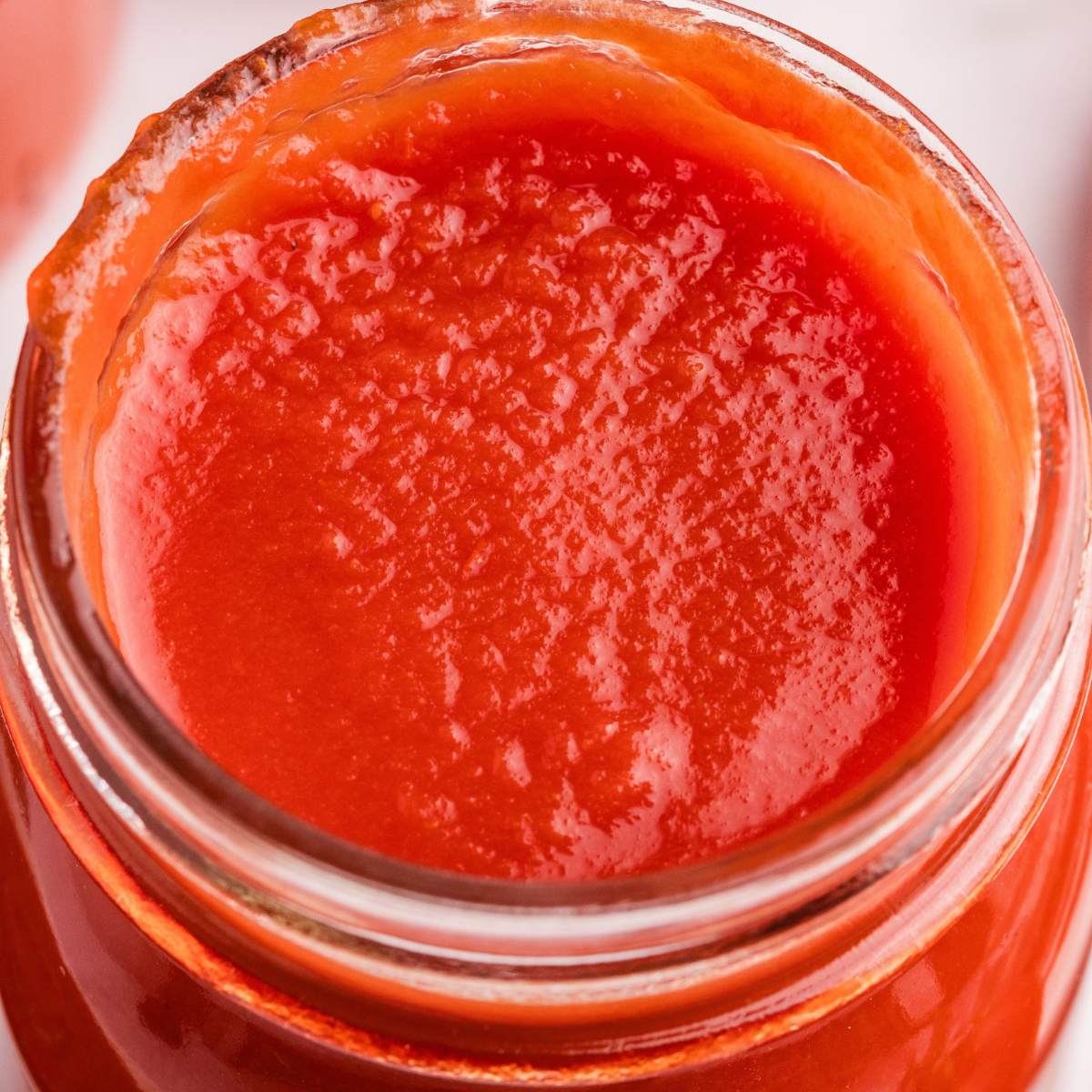overhead view of smooth tomato sauce in jar.