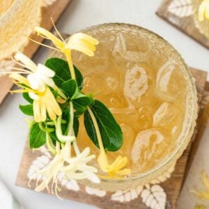 Top view of iced honeysuckle tea with fresh blossoms on top.