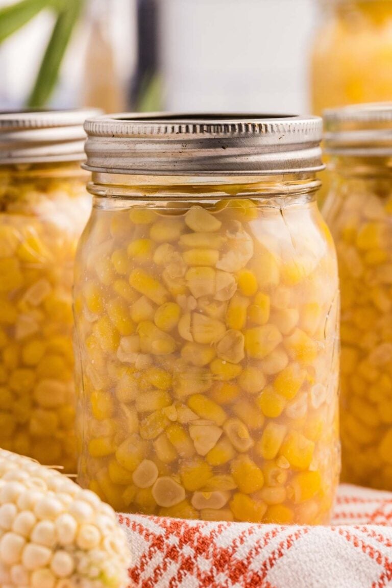 Sealed jar of corn with kernels packed in liquid.