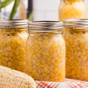 Sealed jar of corn with kernels packed in liquid.