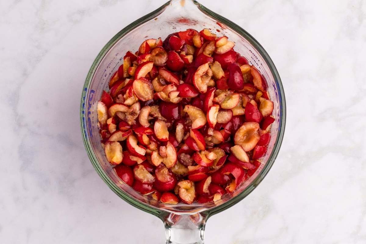 Bowl of chopped fresh cherries mixed with lemon juice and pectin.