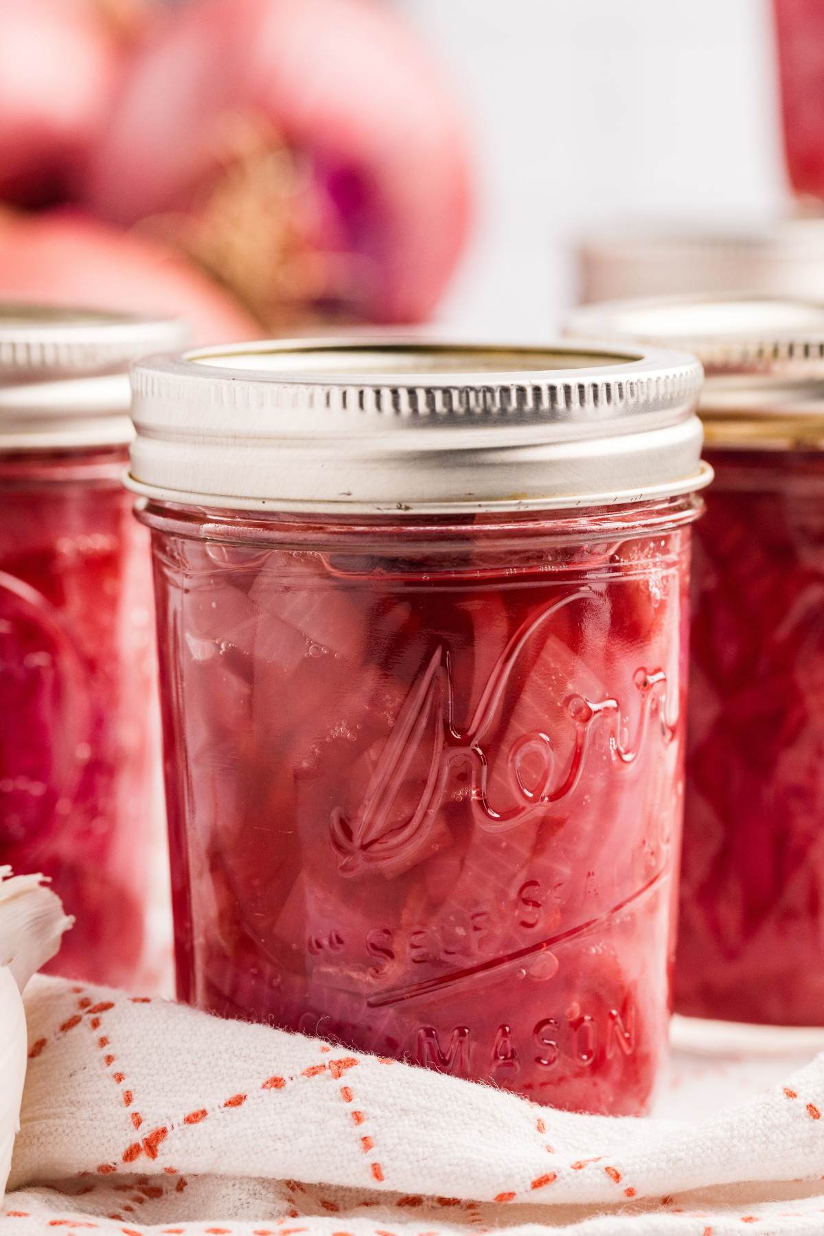 Close-up of sealed half-pint jar of pickled red onions.