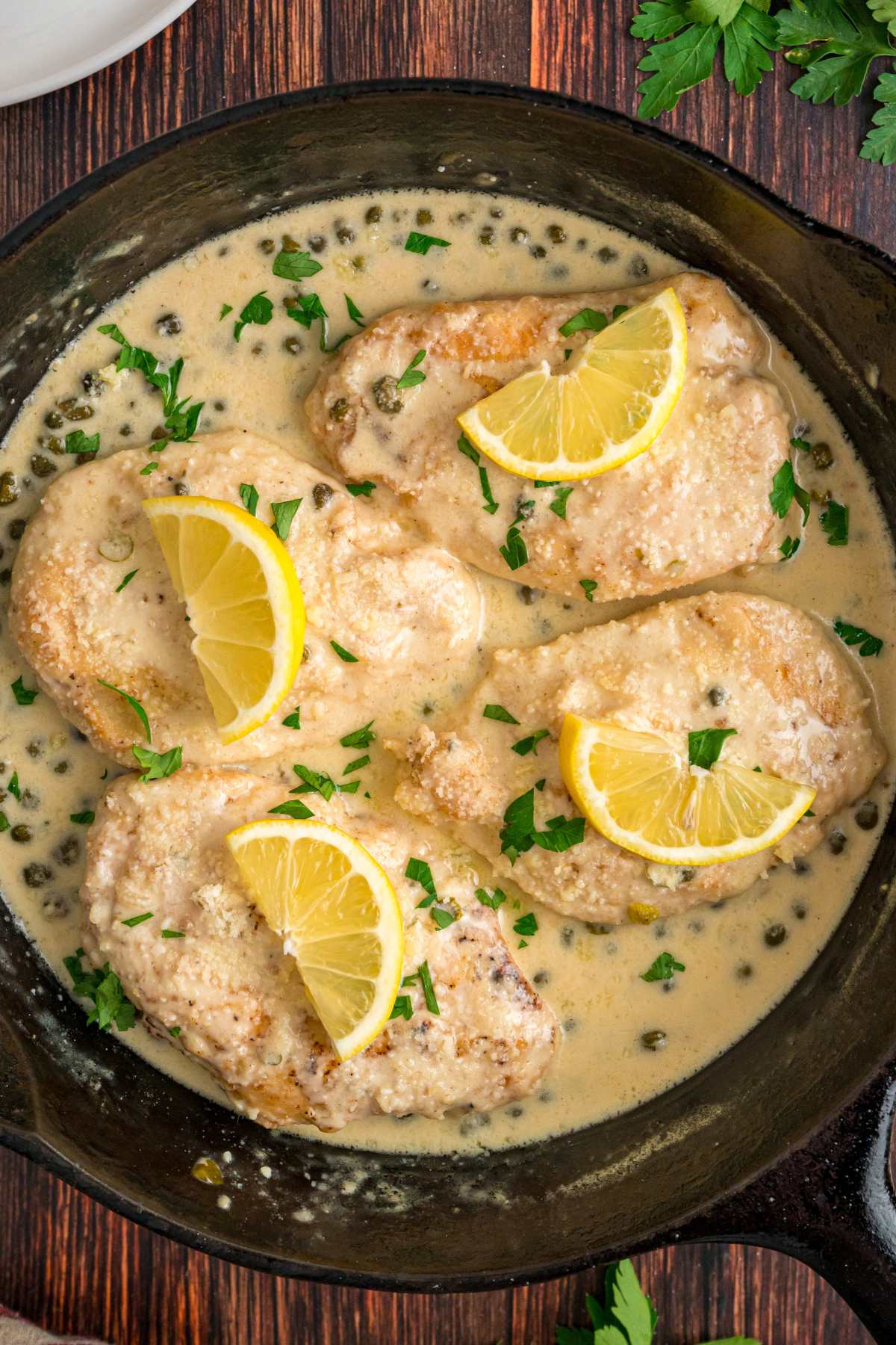 Chicken in lemon cream sauce garnished with parsley and lemon slices.