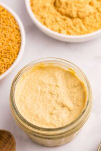 Single jar of creamy yellow homemade Dijon mustard from above view.