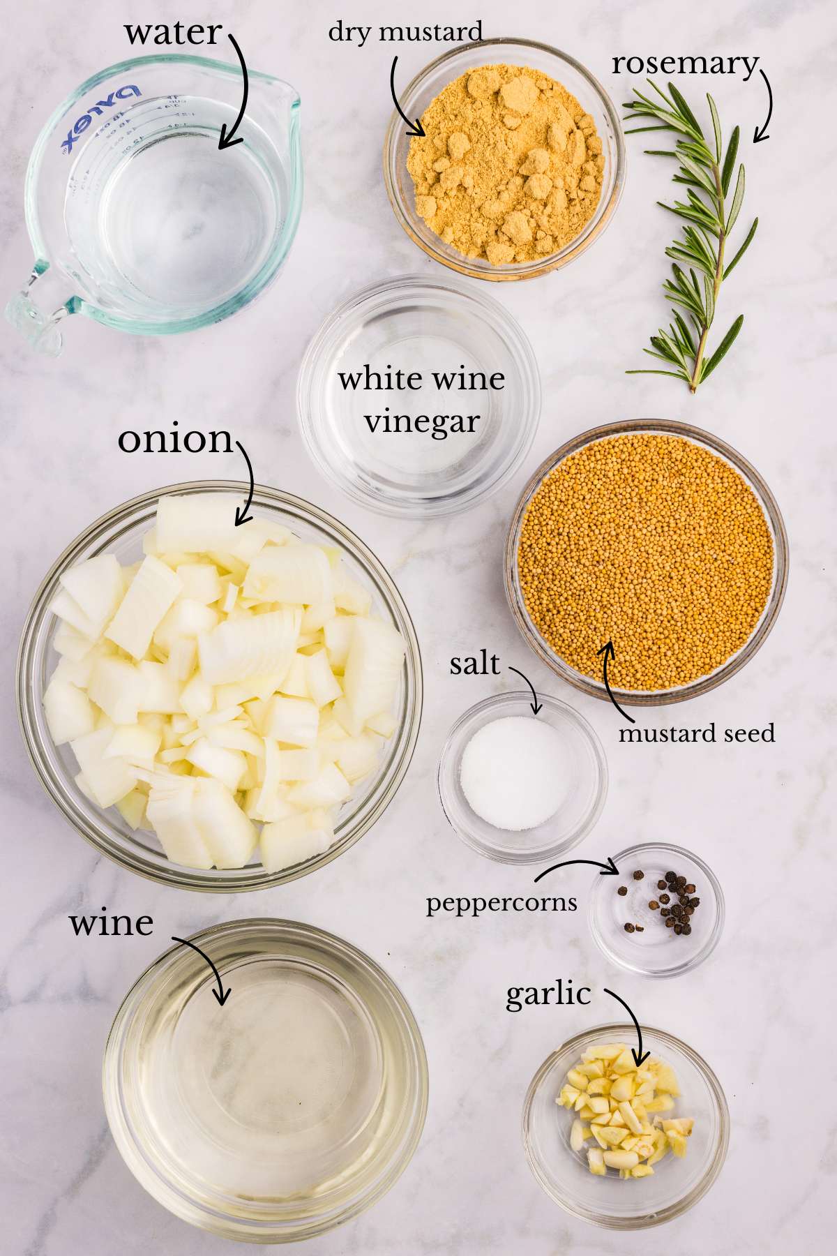Ingredients for Dijon mustard laid out in bowls including wine, onions, and spices.