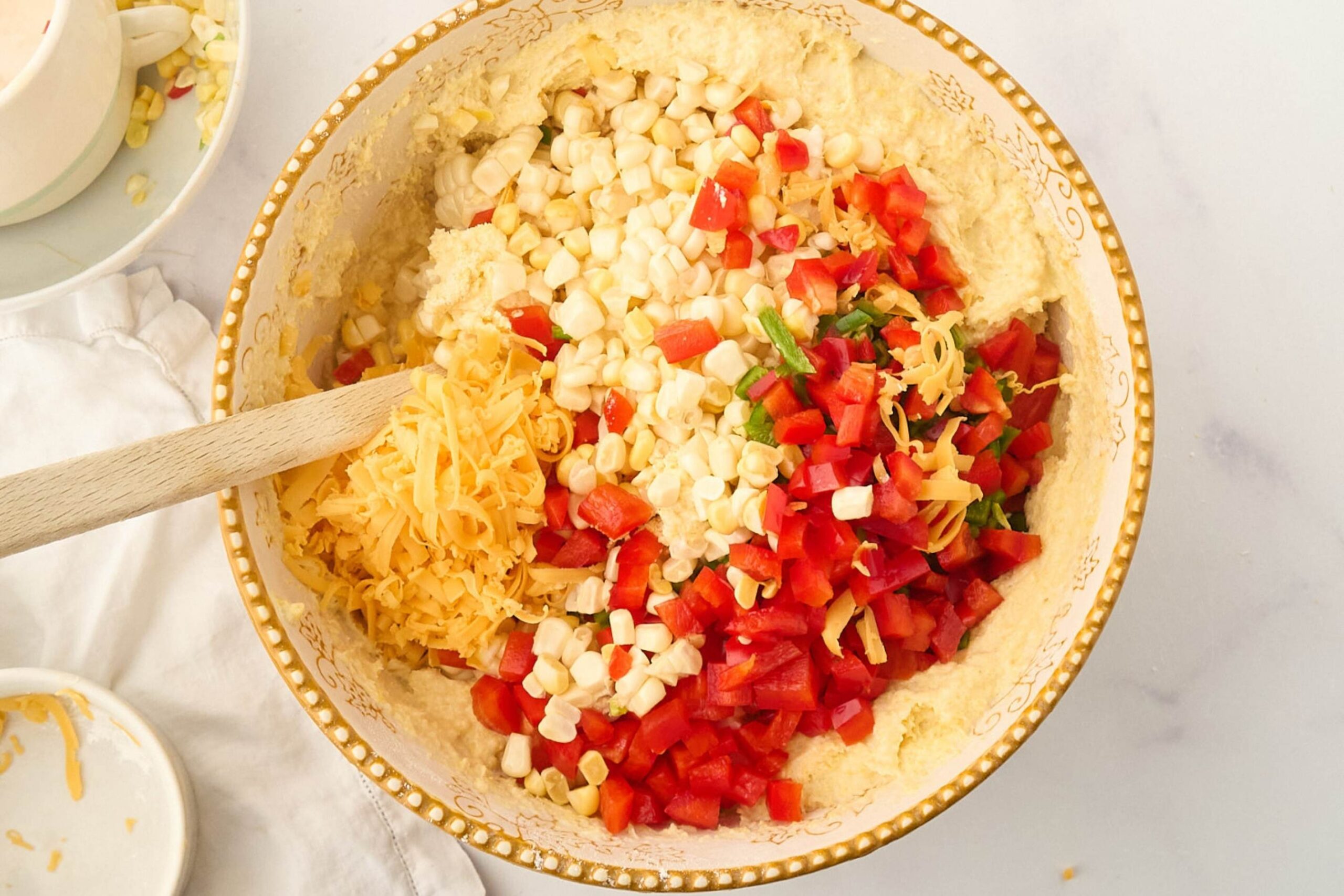 corn and peppers mixed into bowl.